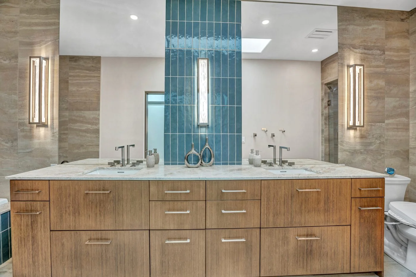 Luxury double vanity bathroom remodel with blue tile accent