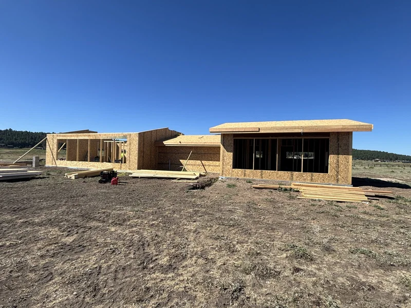 New home construction framing under clear blue sky in Flagstaff